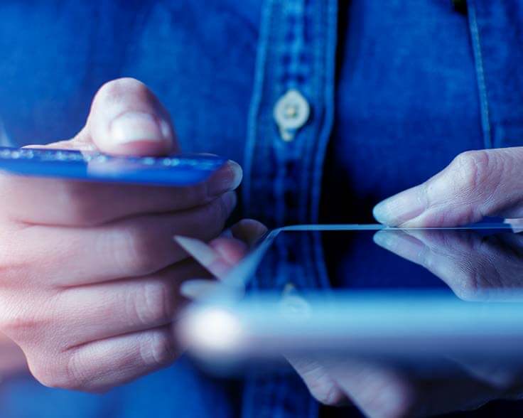 Person holding their phone in one hand and credit card in the other