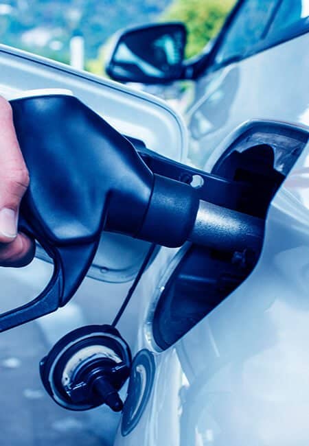 A close up of a person pumping gas into their car.