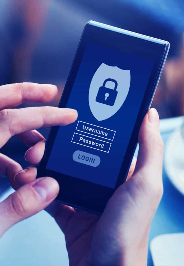A person holding a smart phone on which the screen shows a log in screen