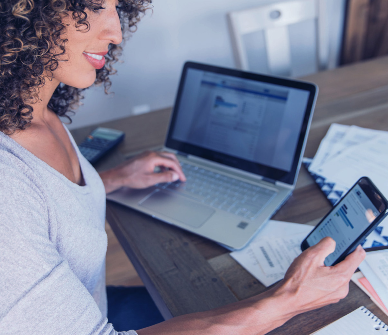 woman paying bills with laptop and mobile
